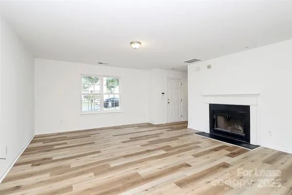 a view of empty room with window and fireplace