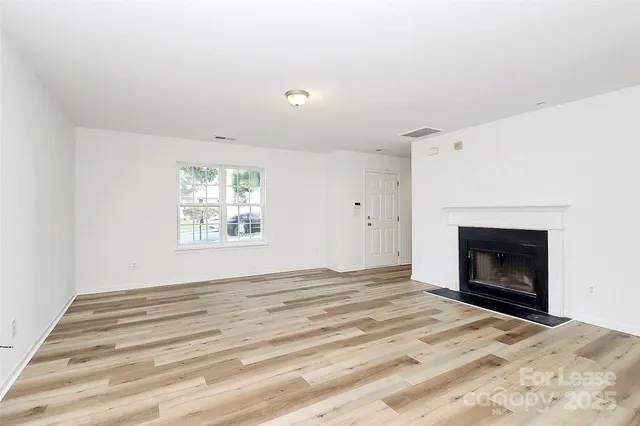 a view of empty room with window and fireplace