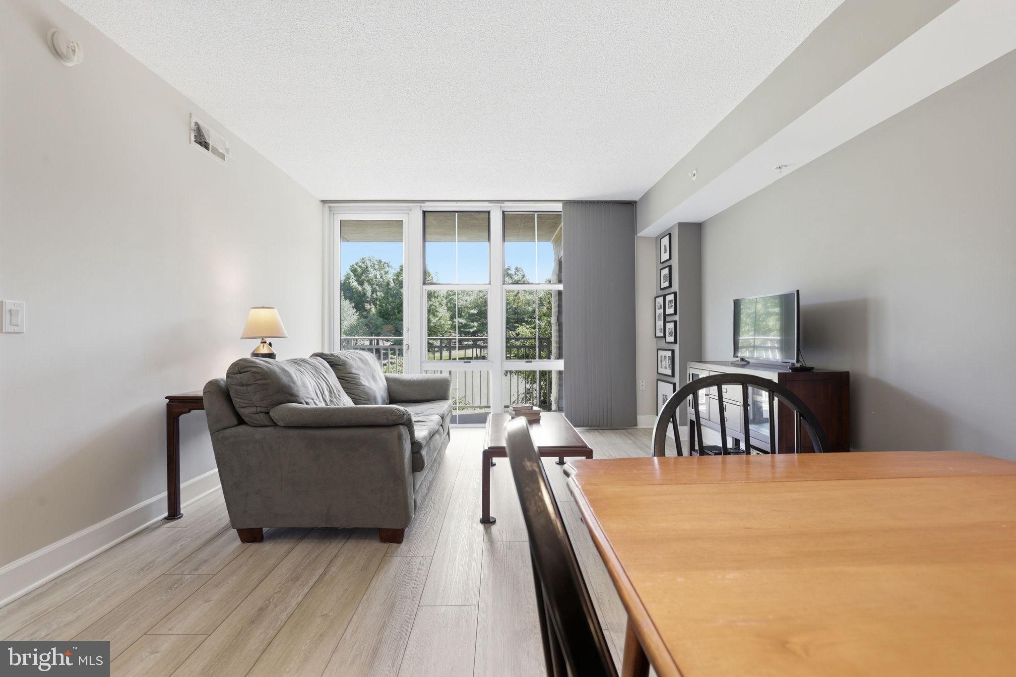 11800 Sunset Hills Road, Unit 218 Reston, VA 20190 - Photo 27 of 38 a bedroom with a bed and large windows