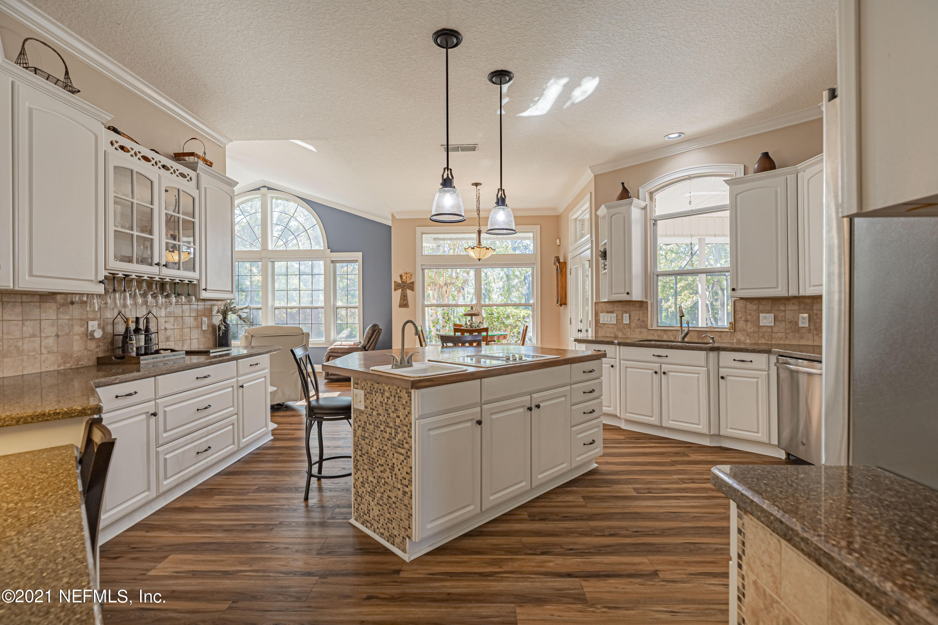1827 Wild Grape Lane Fleming Island, FL 32003 - Photo 13 of 51 a large kitchen with granite countertop a large stove a sink dishwasher a refrigerator and white cabinets with wooden floor
