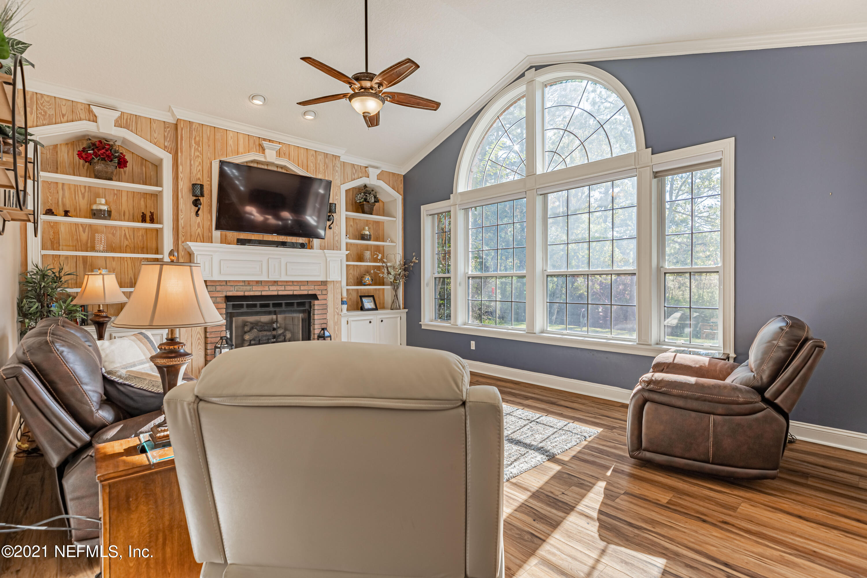 1827 Wild Grape Lane Fleming Island, FL 32003 - Photo 16 of 51 a living room with furniture a fireplace and a flat screen tv