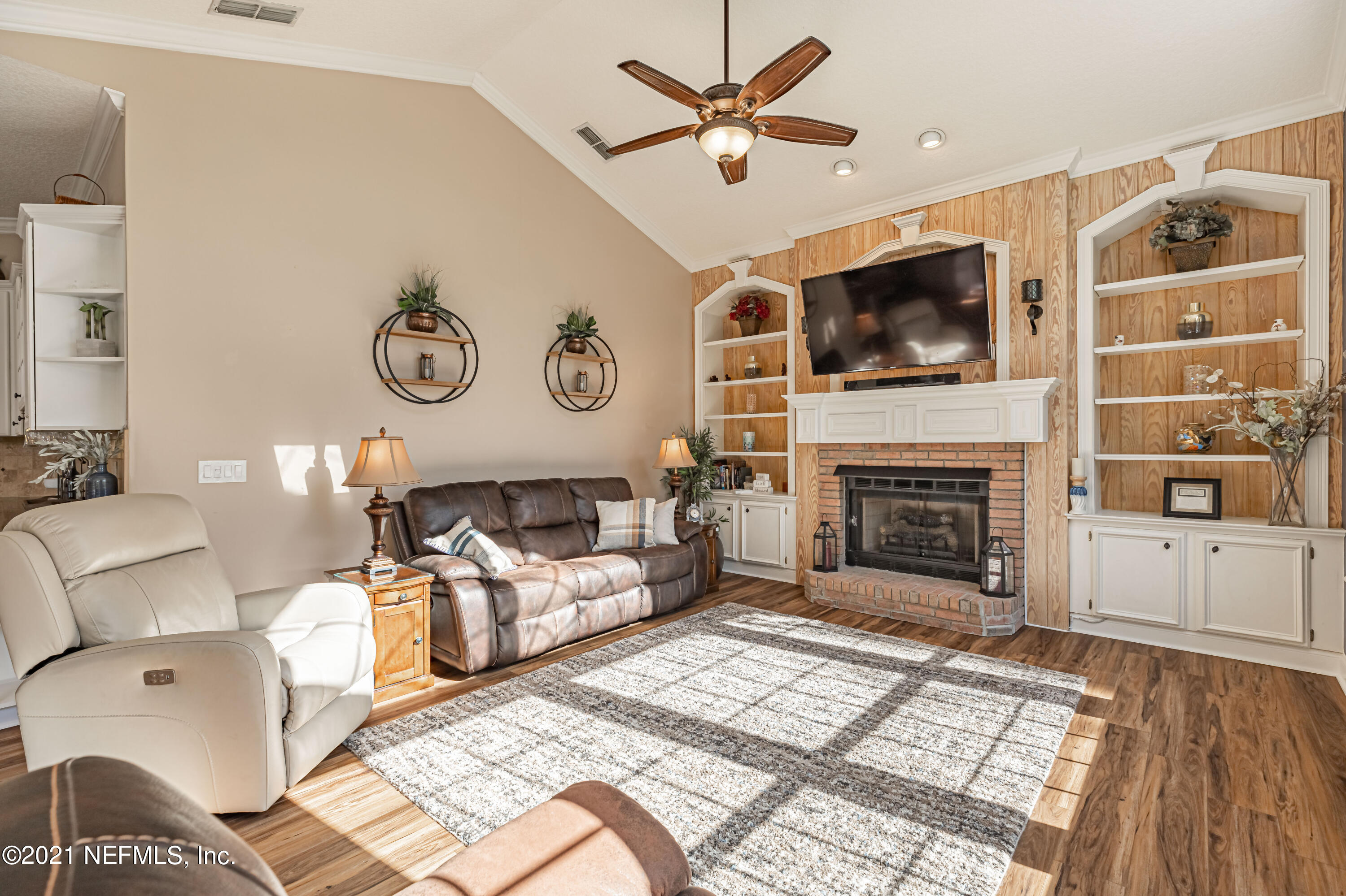 1827 Wild Grape Lane Fleming Island, FL 32003 - Photo 17 of 51 a living room with furniture a flat screen tv and a fireplace