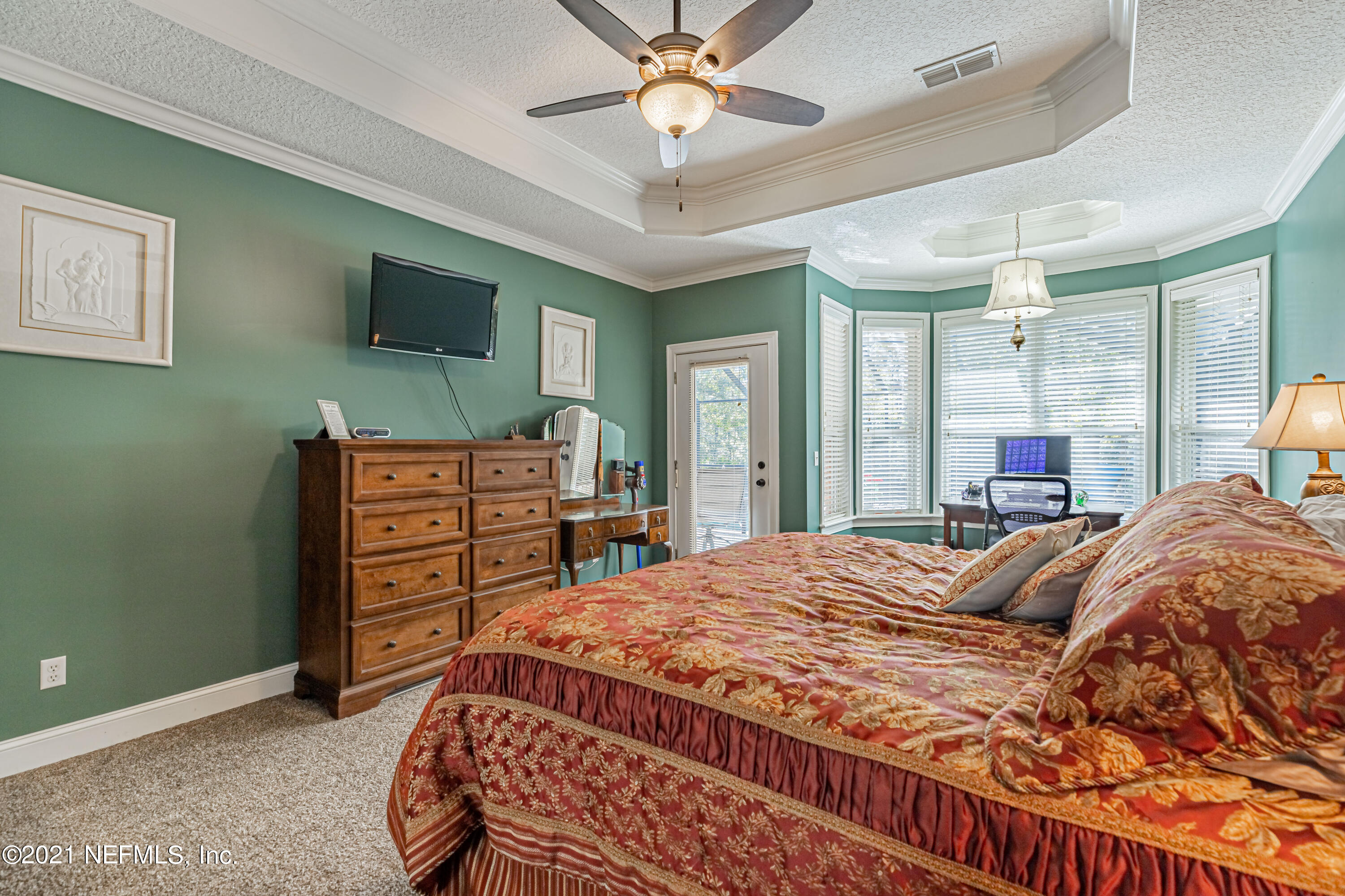 1827 Wild Grape Lane Fleming Island, FL 32003 - Photo 21 of 51 a bedroom with a bed and a flat screen tv