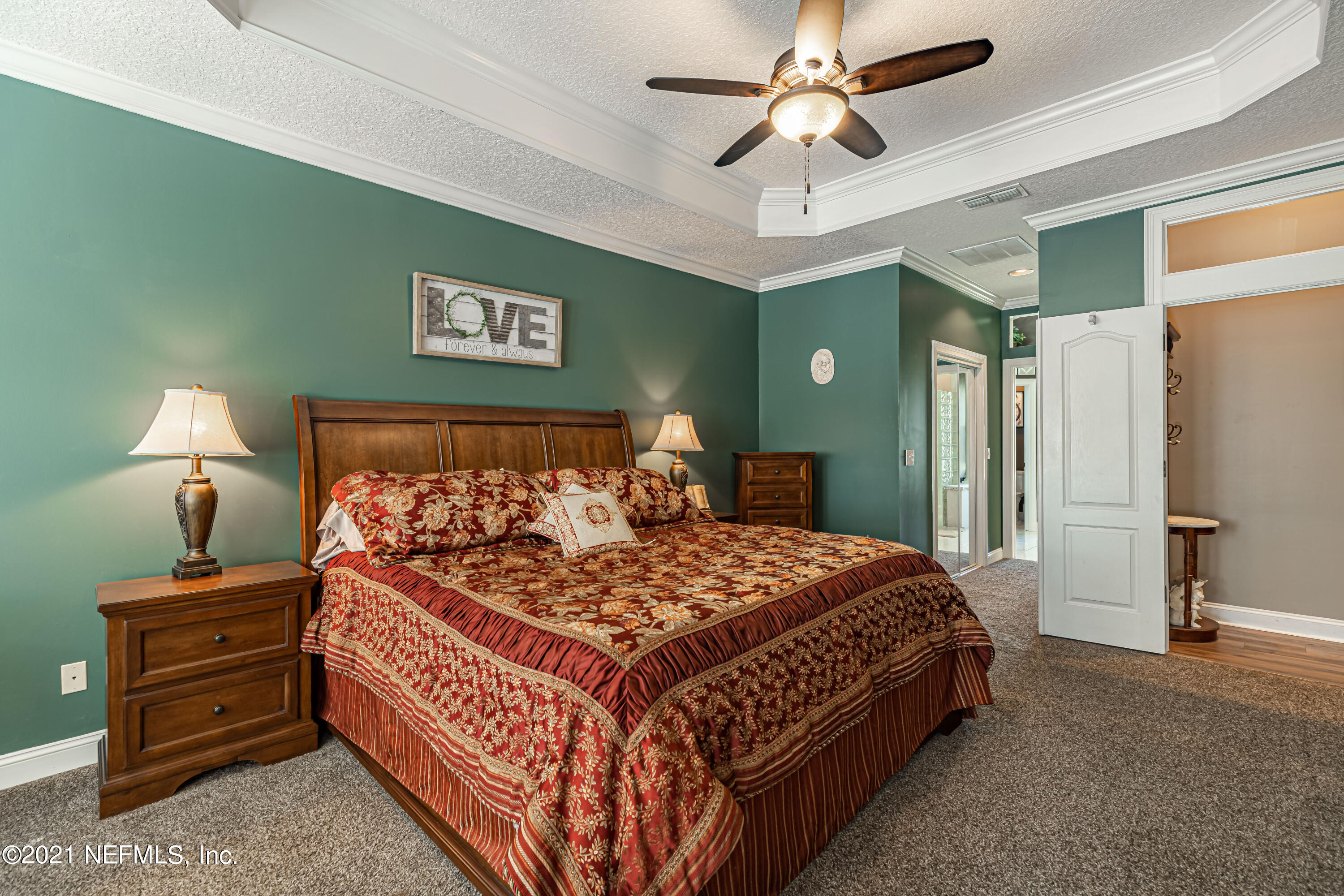 1827 Wild Grape Lane Fleming Island, FL 32003 - Photo 22 of 51 a bedroom with a bed and a chandelier