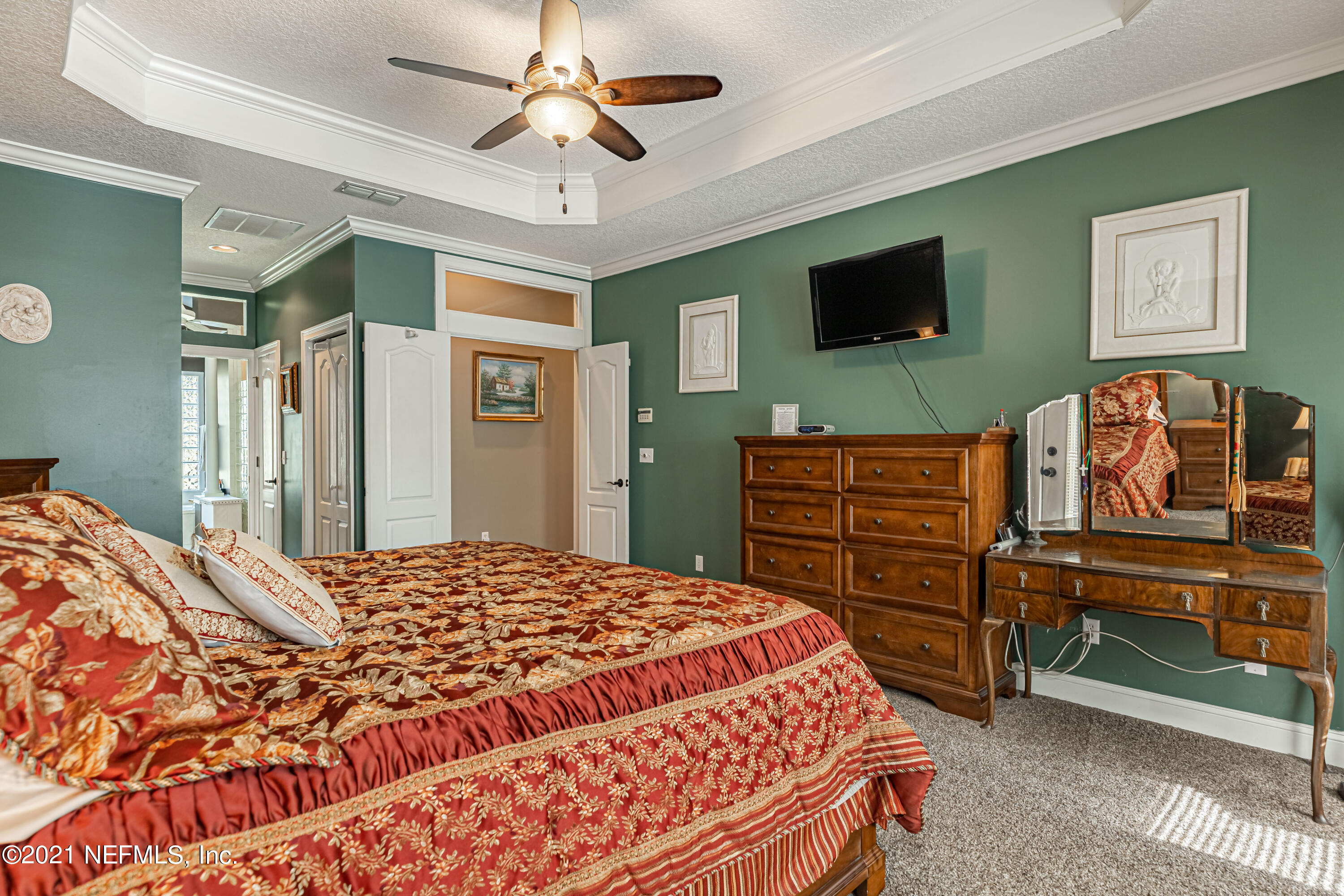 1827 Wild Grape Lane Fleming Island, FL 32003 - Photo 23 of 51 a bedroom with a bed and a flat screen tv