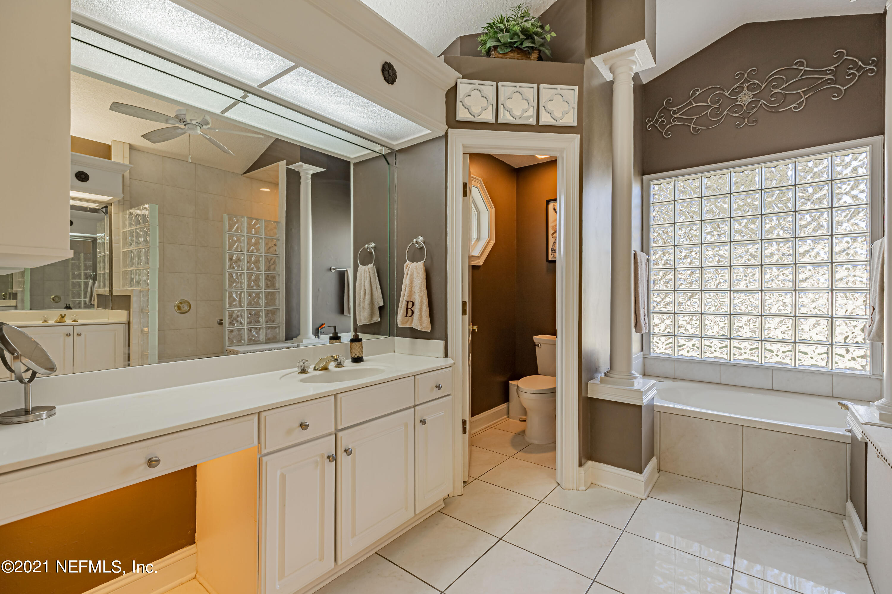 1827 Wild Grape Lane Fleming Island, FL 32003 - Photo 26 of 51 a spacious bathroom with a sink mirror and a bathtub