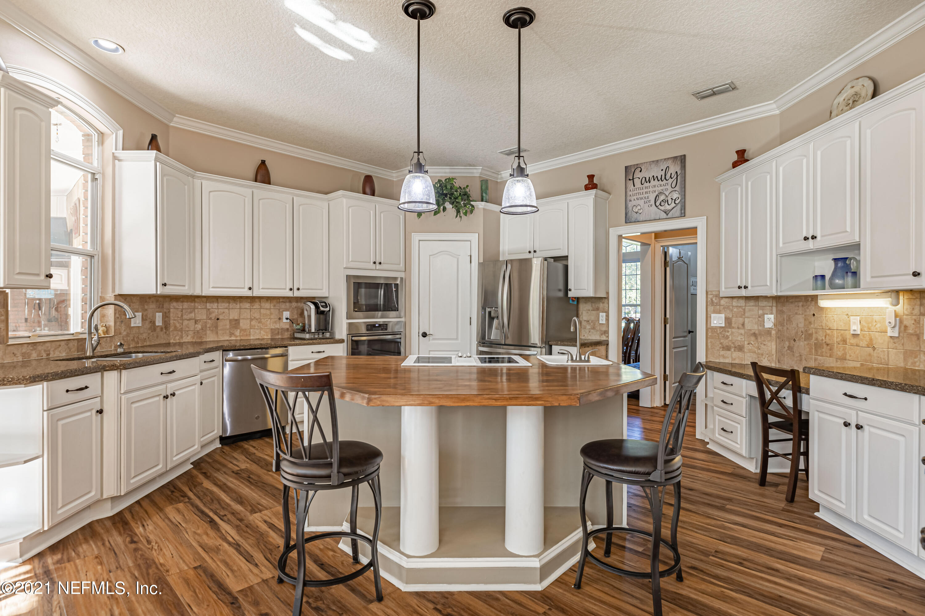 1827 Wild Grape Lane Fleming Island, FL 32003 - Photo 10 of 51 a kitchen with stainless steel appliances kitchen island a table and chairs in it