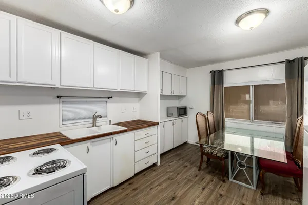 a kitchen with a sink a stove a refrigerator cabinets and dining table