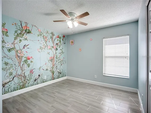 a view of a livingroom with window and ceiling fan