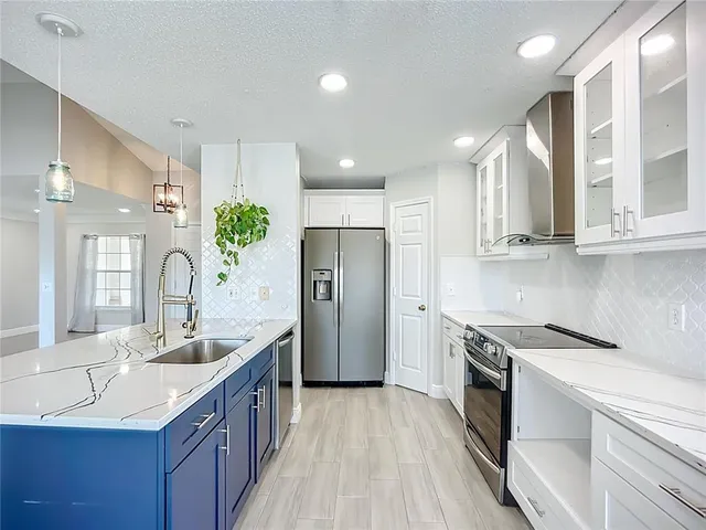 a kitchen with stainless steel appliances granite countertop a sink stove and refrigerator