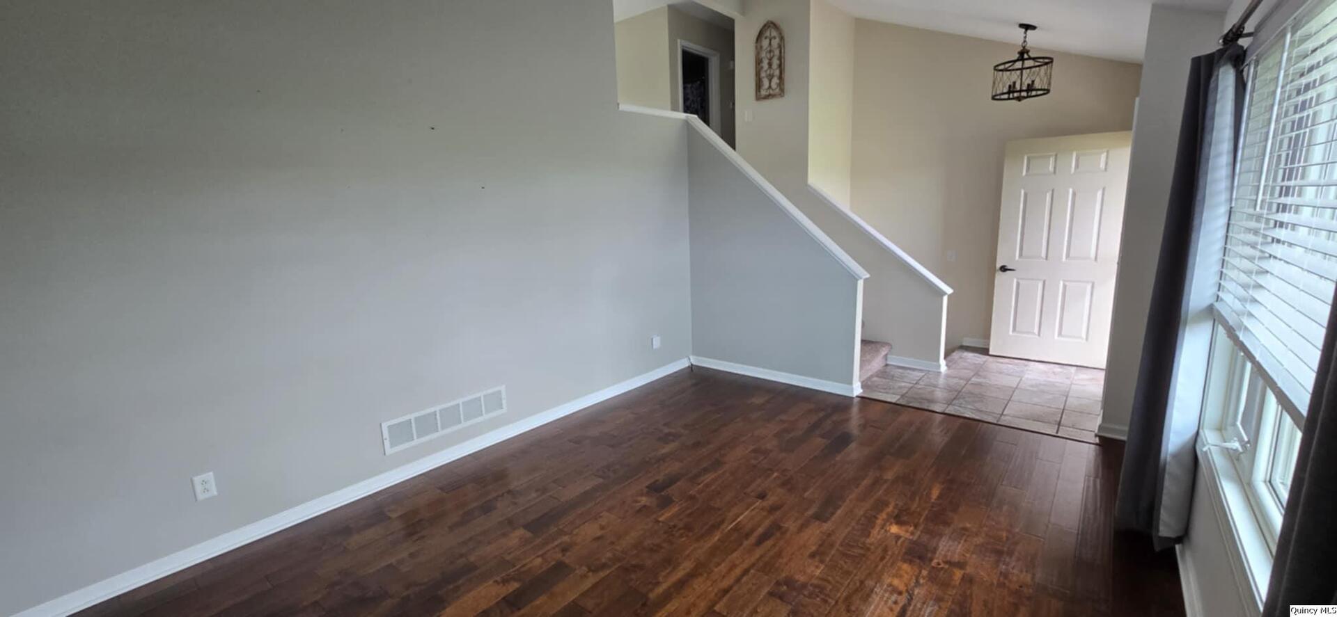 200 Dallas Road Carthage, IL 62321 - Photo 8 of 20 an empty room with wooden floor and staircase