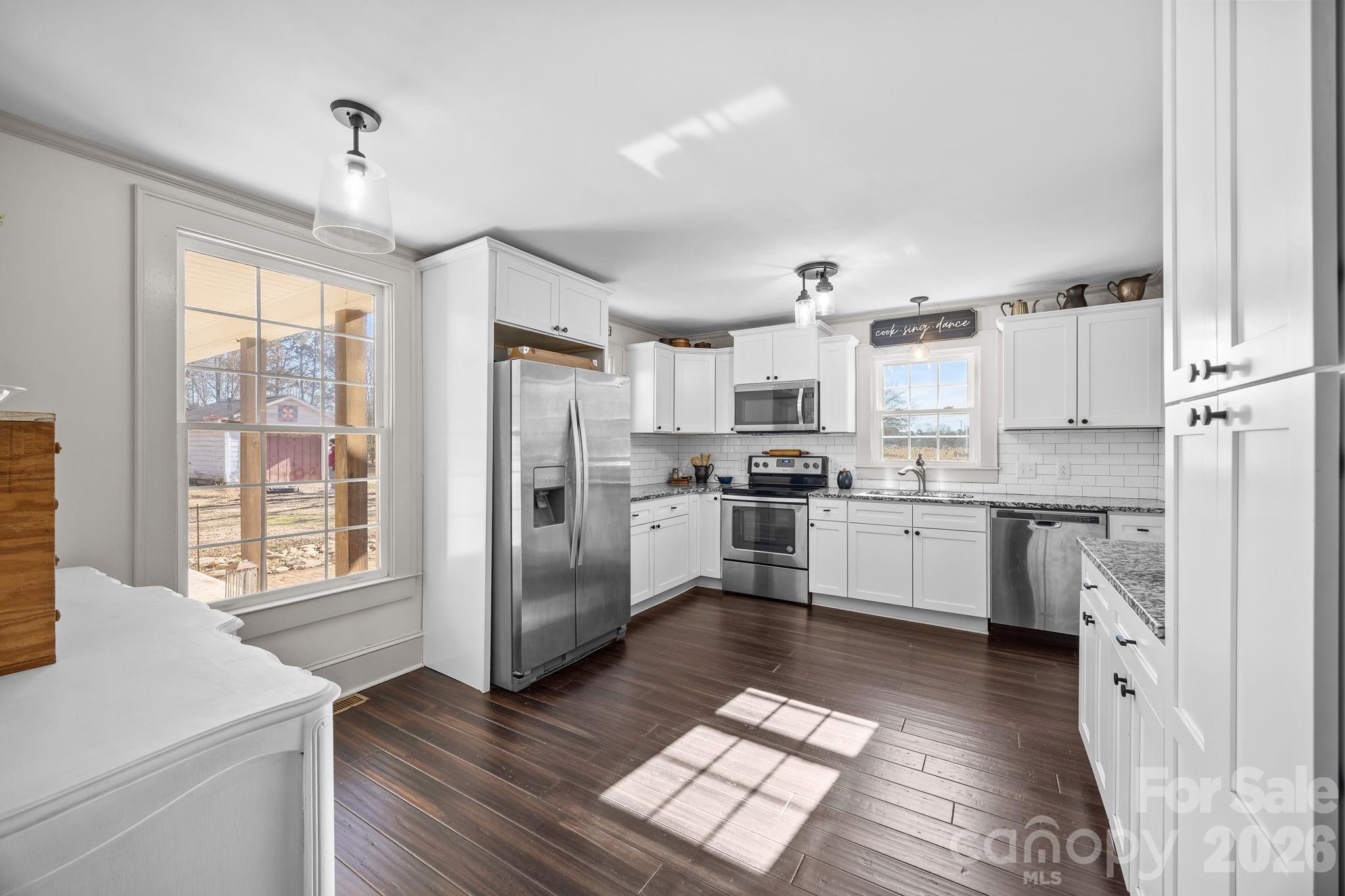 455 Eudy Road China Grove, NC 28023 - Photo 12 of 32 a kitchen with stainless steel appliances granite countertop a refrigerator a sink dishwasher a stove with white cabinets and wooden floor