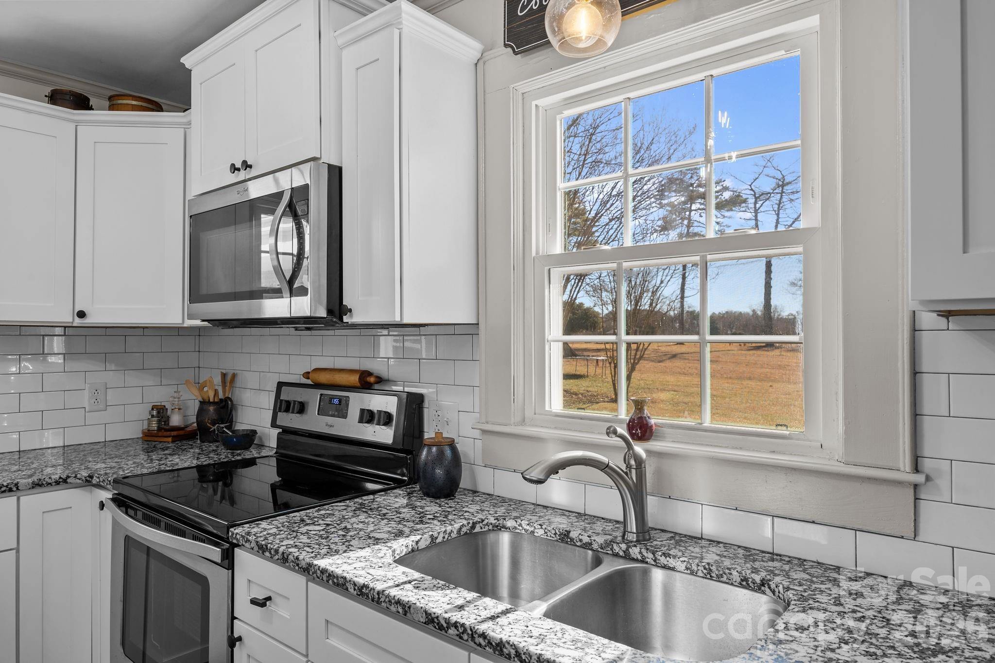 455 Eudy Road China Grove, NC 28023 - Photo 15 of 32 a kitchen with granite countertop a sink stainless steel appliances and cabinets