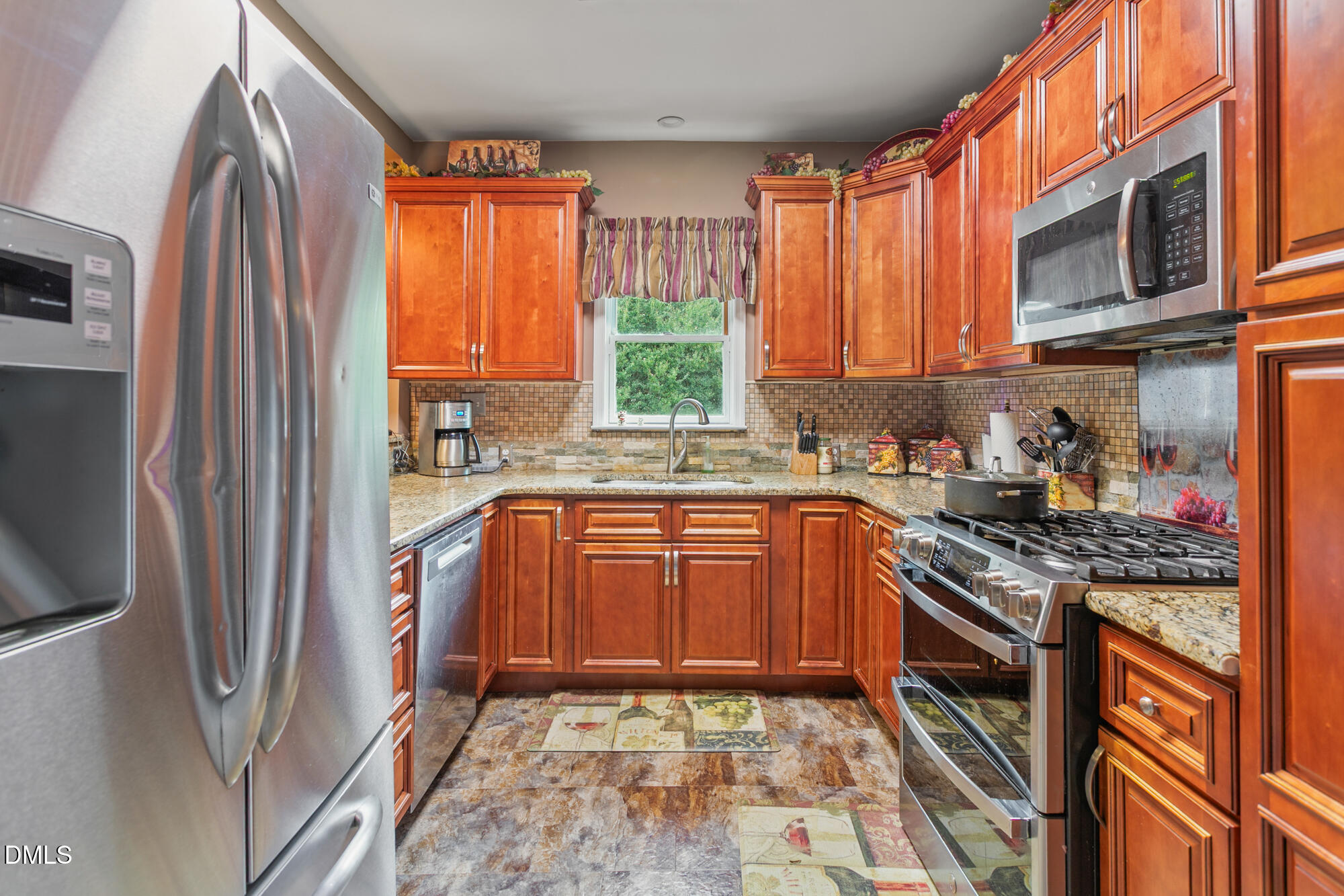 3163 Saul Loop Road Elon, NC 27244 - Photo 12 of 44 a kitchen with stainless steel appliances granite countertop a refrigerator a sink a stove a washer and dryer next to a window
