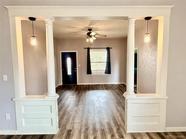 a view of a hallway with wooden floor and a cabinet