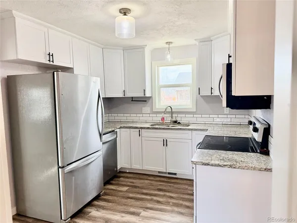 a kitchen with a refrigerator sink and stove