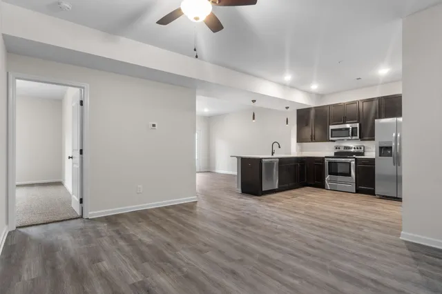 a large kitchen with kitchen island a large counter top stainless steel appliances and cabinets