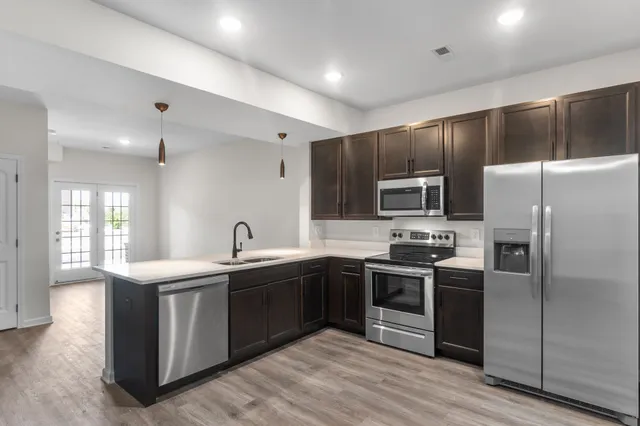 a kitchen with stainless steel appliances granite countertop a sink stove and refrigerator