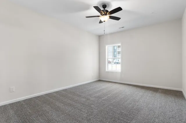 an empty room with a window and a fan