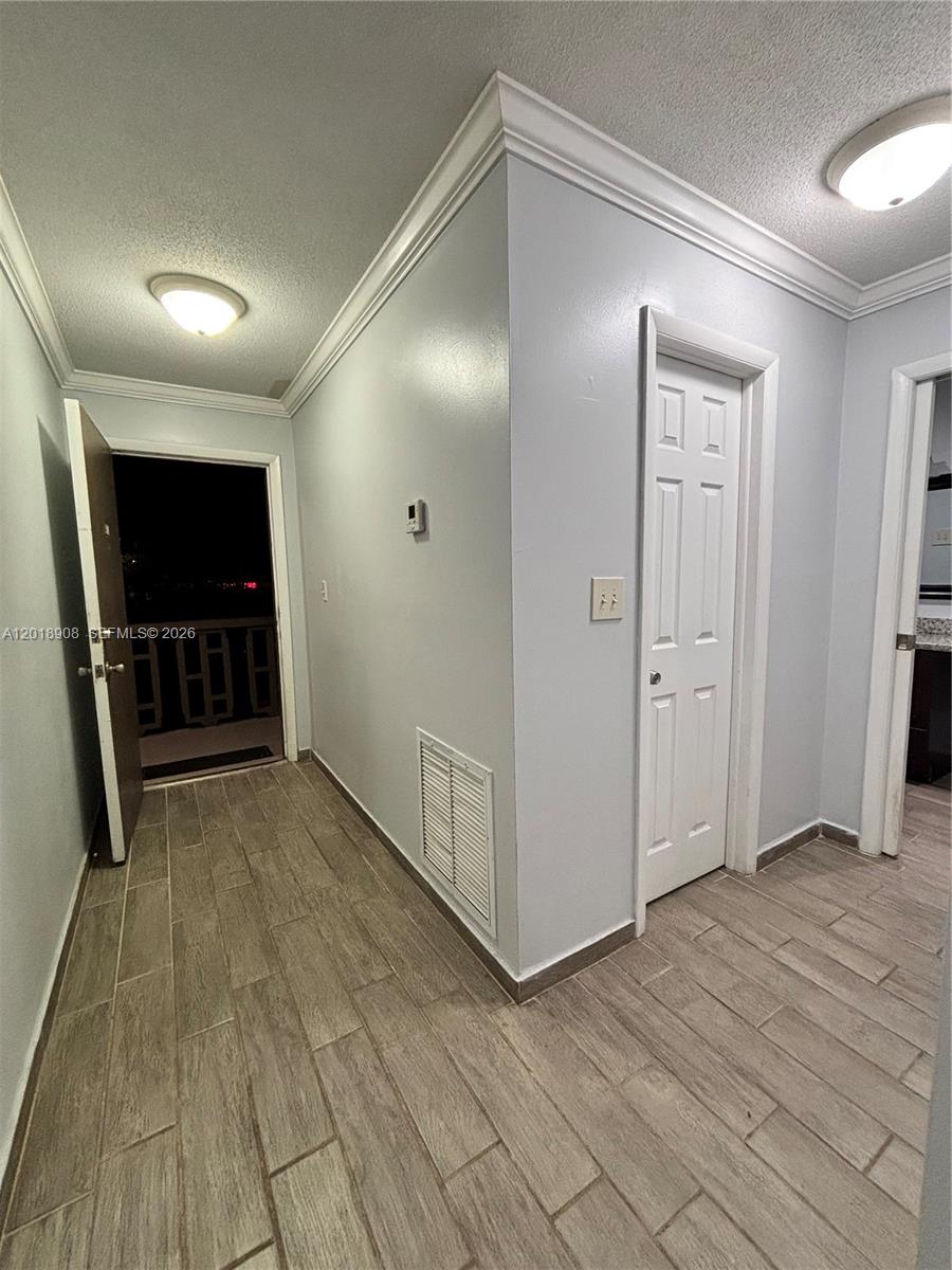 1480 East Sample Road, Unit 209 Pompano Beach, FL 33064 - Photo 13 of 24 an empty room with wooden floor closet and windows