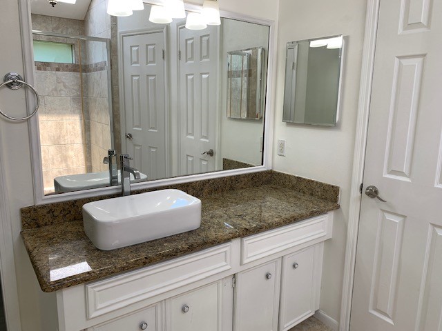 6650 Grove Field Lane Houston, TX 77084 - Photo 12 of 18 a bathroom with a granite countertop sink and a mirror
