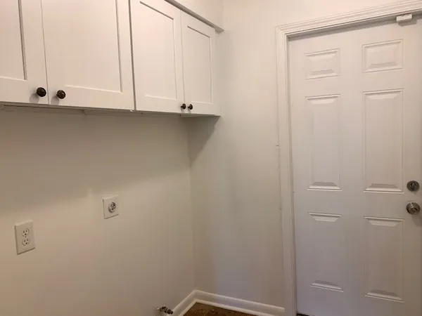a view of cabinets and utility room with window