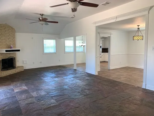 an empty room with fan and windows