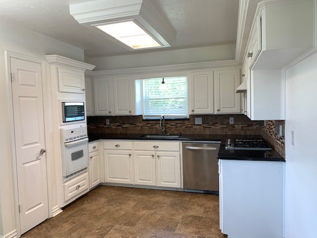 6650 Grove Field Lane Houston, TX 77084 - Photo 5 of 18 a kitchen with granite countertop white cabinets and white appliances