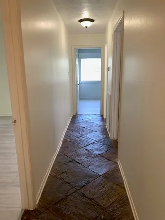 a view of a hallway with wooden floor