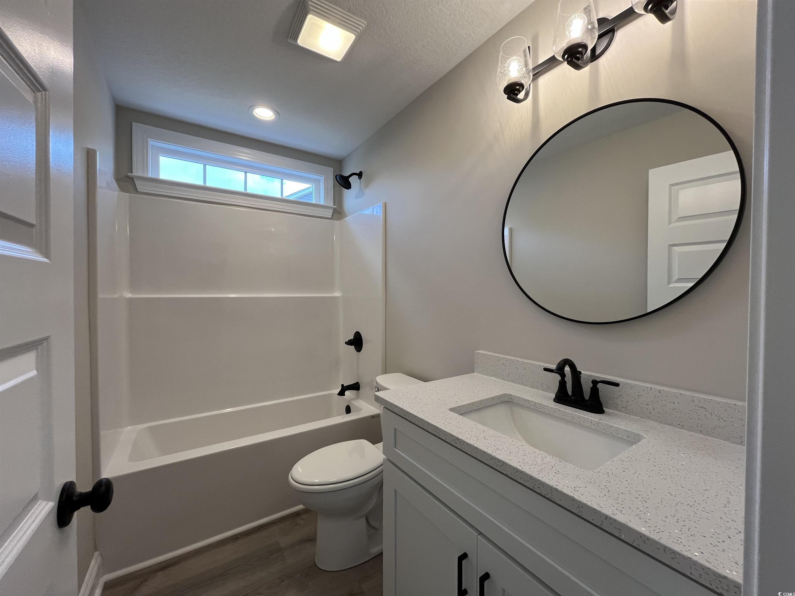 8229 Kerl Road Aynor, SC 29511 - Photo 15 of 19 Full bathroom with vanity, wood-type flooring, tub