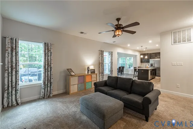 a large kitchen with granite countertop lots of counter space dining table and stainless steel appliances