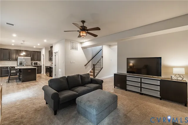 a kitchen with a stove center island wooden floor and living room