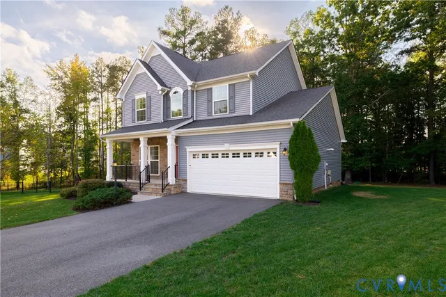 a view of a house with a yard and a garage