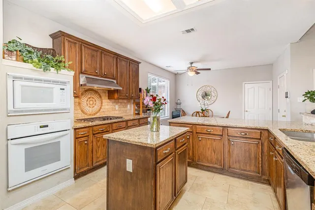 a kitchen with stainless steel appliances granite countertop a sink stove and cabinets