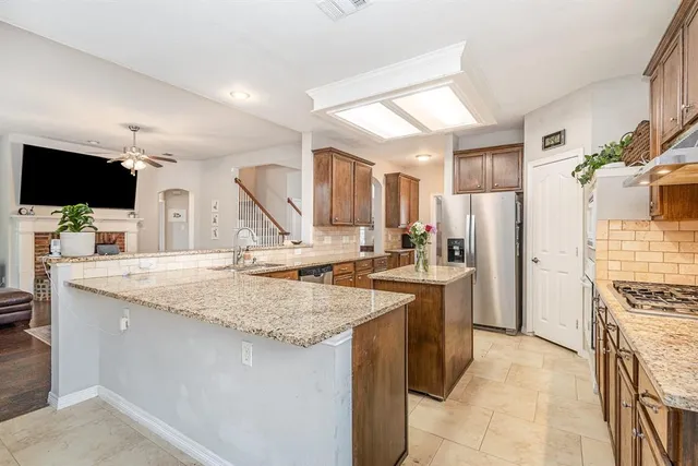 a kitchen with stainless steel appliances granite countertop a sink stove and refrigerator