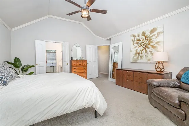 a spacious bedroom with a bed a couch and a painting on the wall