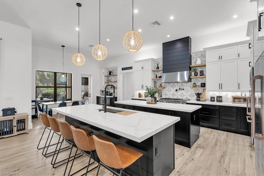 4186 3rd Avenue Northwest Naples, FL 34119 - Photo 14 of 50 a kitchen with stainless steel appliances kitchen island a table and chairs in it