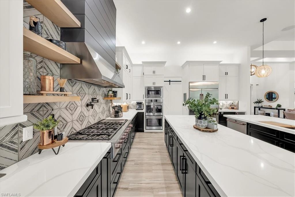 4186 3rd Avenue Northwest Naples, FL 34119 - Photo 16 of 50 a kitchen with a sink stove and wooden cabinets