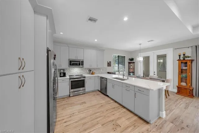 a kitchen with stainless steel appliances a microwave sink refrigerator and cabinets