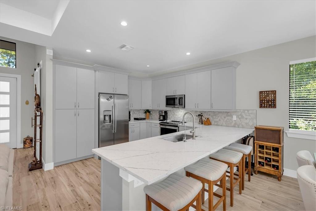 4186 3rd Avenue Northwest Naples, FL 34119 - Photo 43 of 50 a kitchen with stainless steel appliances a microwave sink refrigerator and cabinets