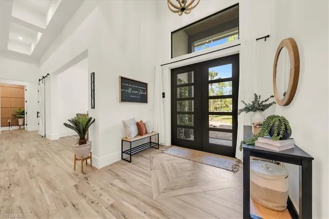 a living room with furniture a potted plant and a large window