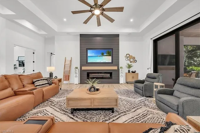 a living room with furniture a fireplace and a large window