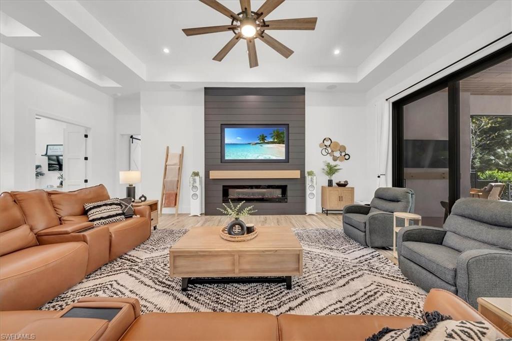 4186 3rd Avenue Northwest Naples, FL 34119 - Photo 8 of 50 a living room with furniture a fireplace and a large window