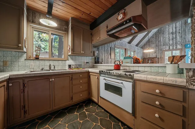 a living room with furniture a fireplace and large windows