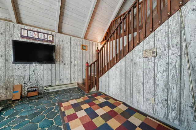 a view of a house with a large tree in front of it