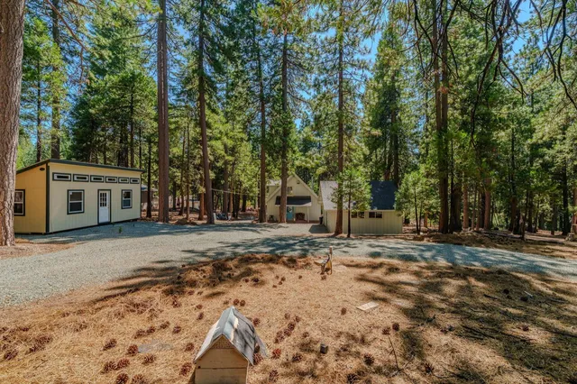 a view of a house with wooden deck and trees
