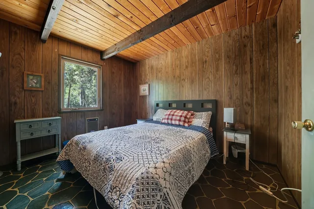a bed sitting in a spacious bedroom next to a window