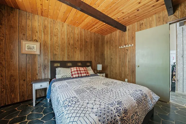 a bed sitting in a bedroom next to a bathroom