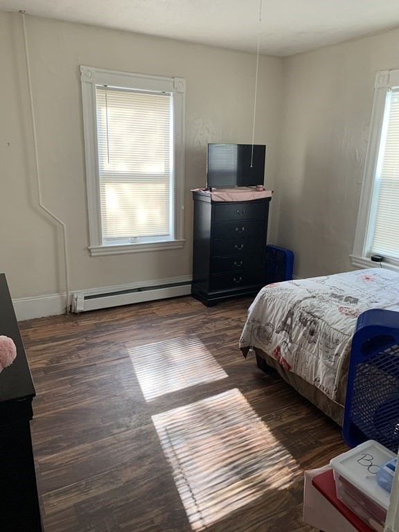 202-204 Lawrence Street Lawrence, MA 01841 - Photo 6 of 12 a bedroom with a bed and window