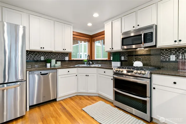 a kitchen with stainless steel appliances granite countertop a stove a sink and a refrigerator